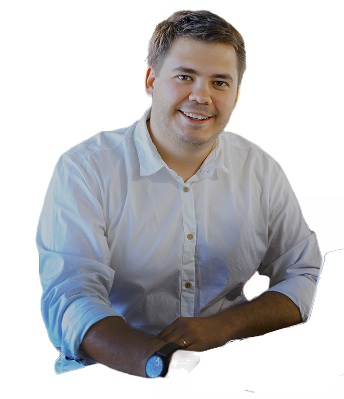 A person smiling while sitting at a desk, wearing a white button-up shirt. The background is removed, emphasizing the subject. This image relates to software development and teamwork.